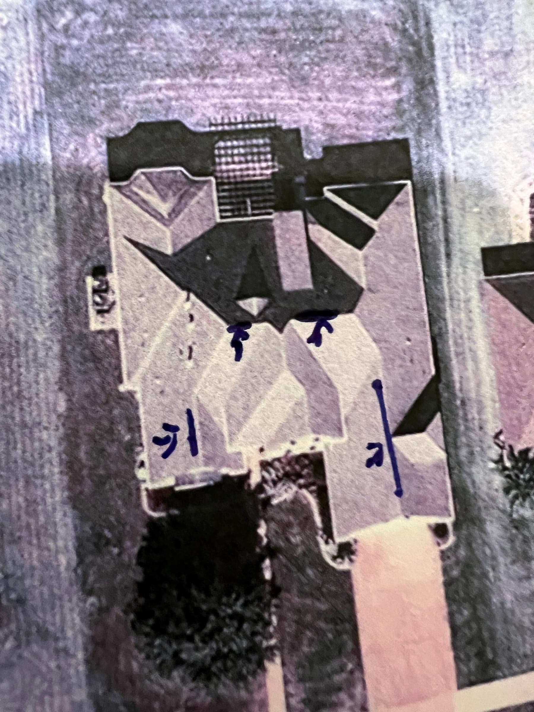 Photographed printout of an aerial roof diagram with several roof areas marked in blue pen